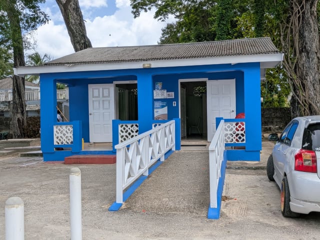 Blue-and-white public washroom building with an entrance ramp at Folkestone Beach in St. James, Barbados.