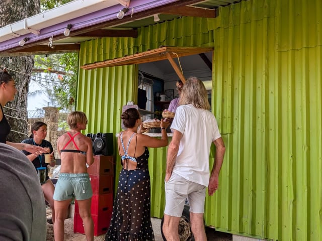 Customers ordering at the service window of the lime-green Sea and Sand Bar at Folkestone Beach in St. James, Barbados.