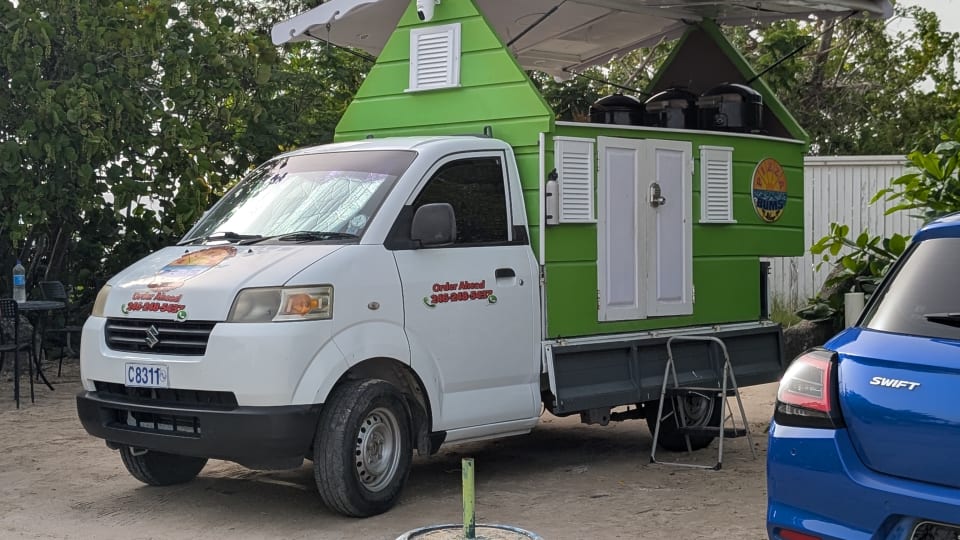 Lime-green Pizza Bums food truck parked in the Heywoods Beach public parking area.