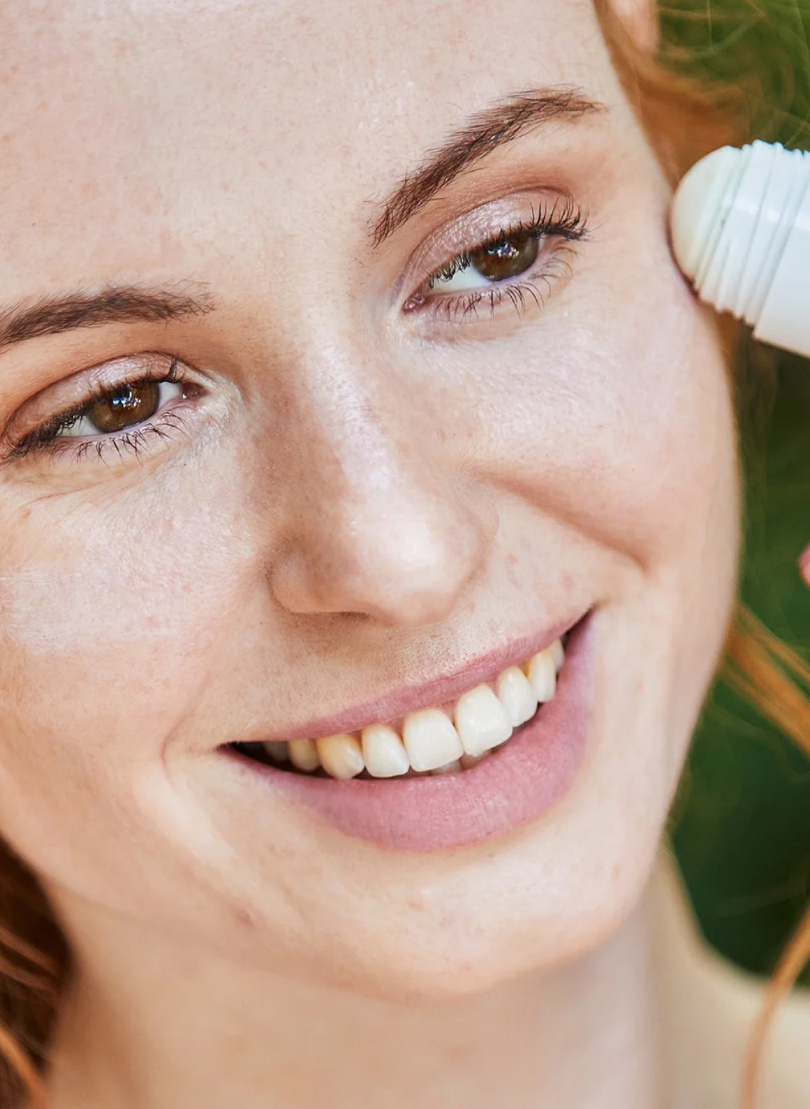 Smiling woman applying makeup