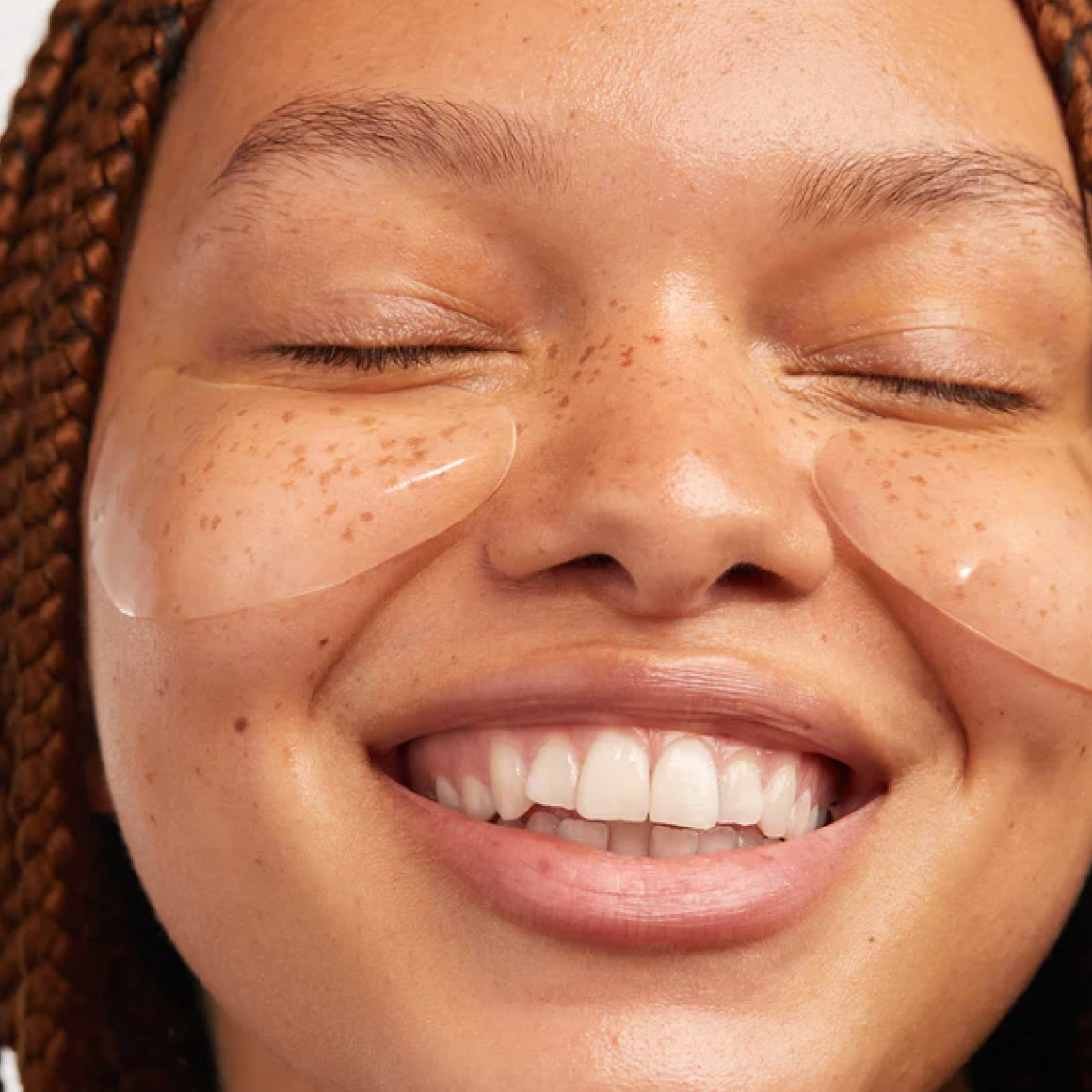 Close up shot of a smiling woman with eye pads