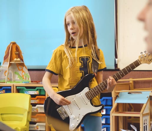 irock student holding guitar