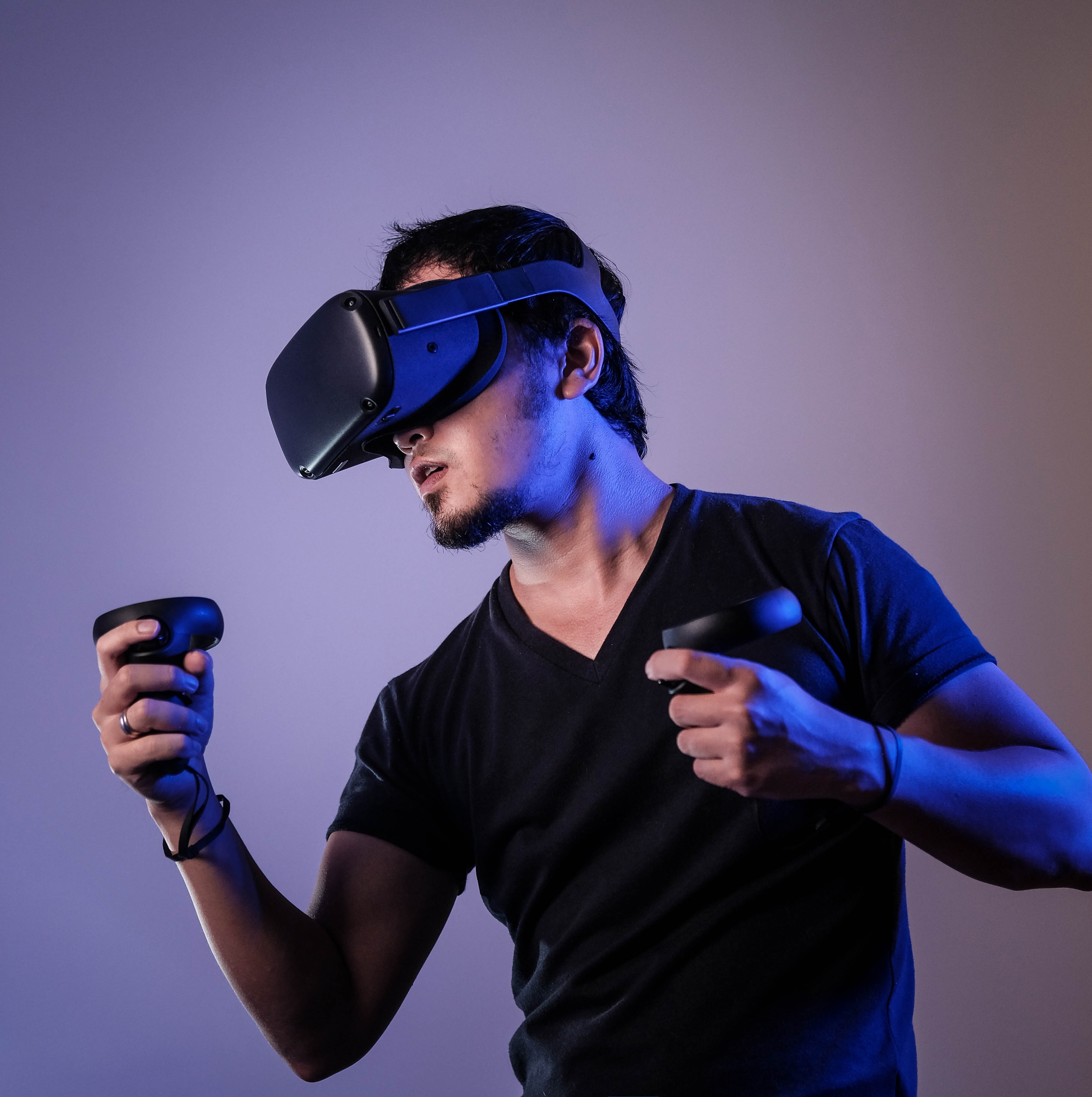 Man wearing a VR headset and holding motion controllers for a VR game