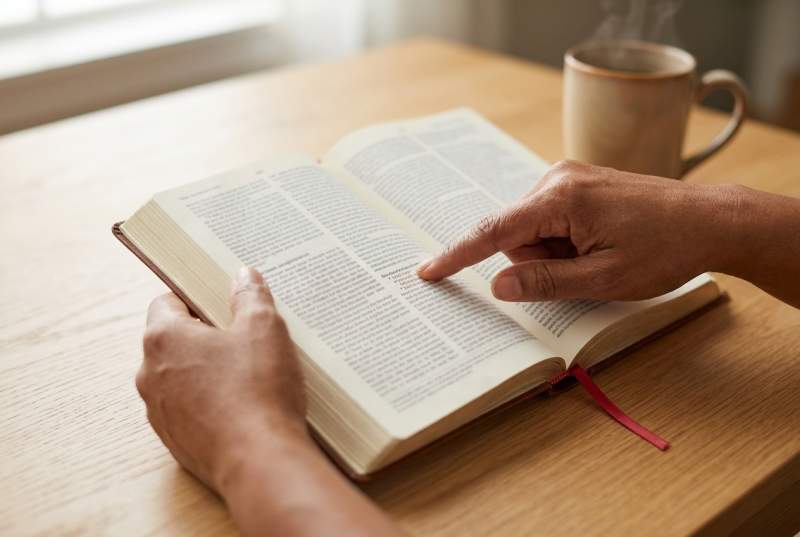 An open prayer book showing Scripture references printed alongside each prayer