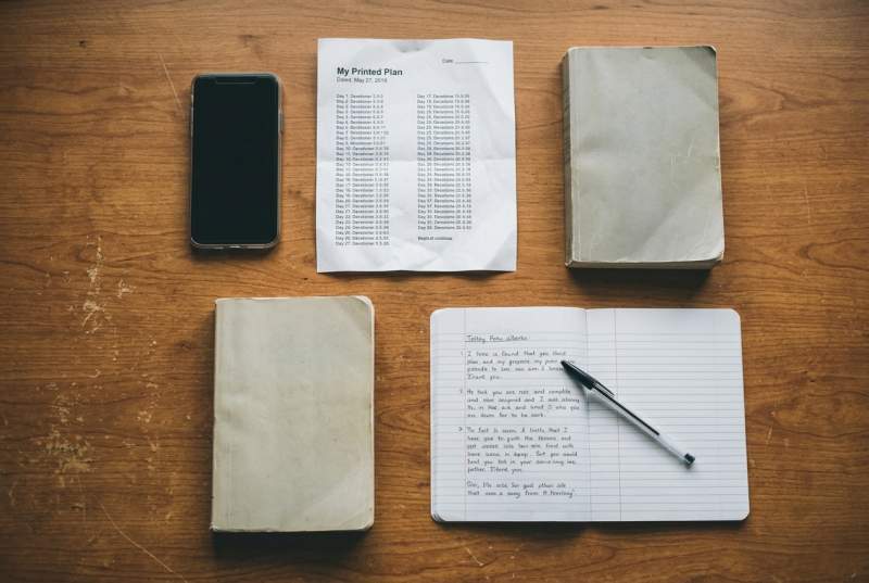 Phone screen showing a Bible app next to social media icons, representing passive digital consumption