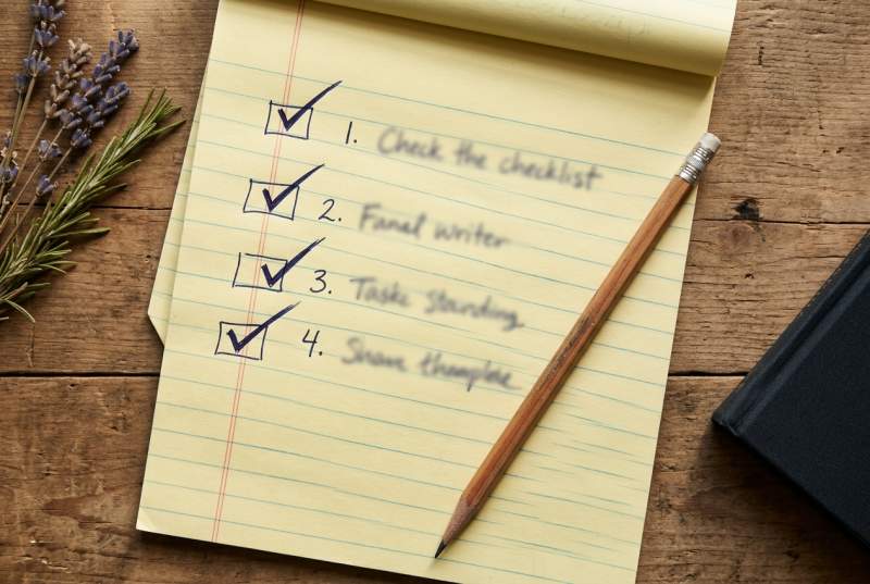 Four-question checklist on a notepad beside a cup of herbal tea