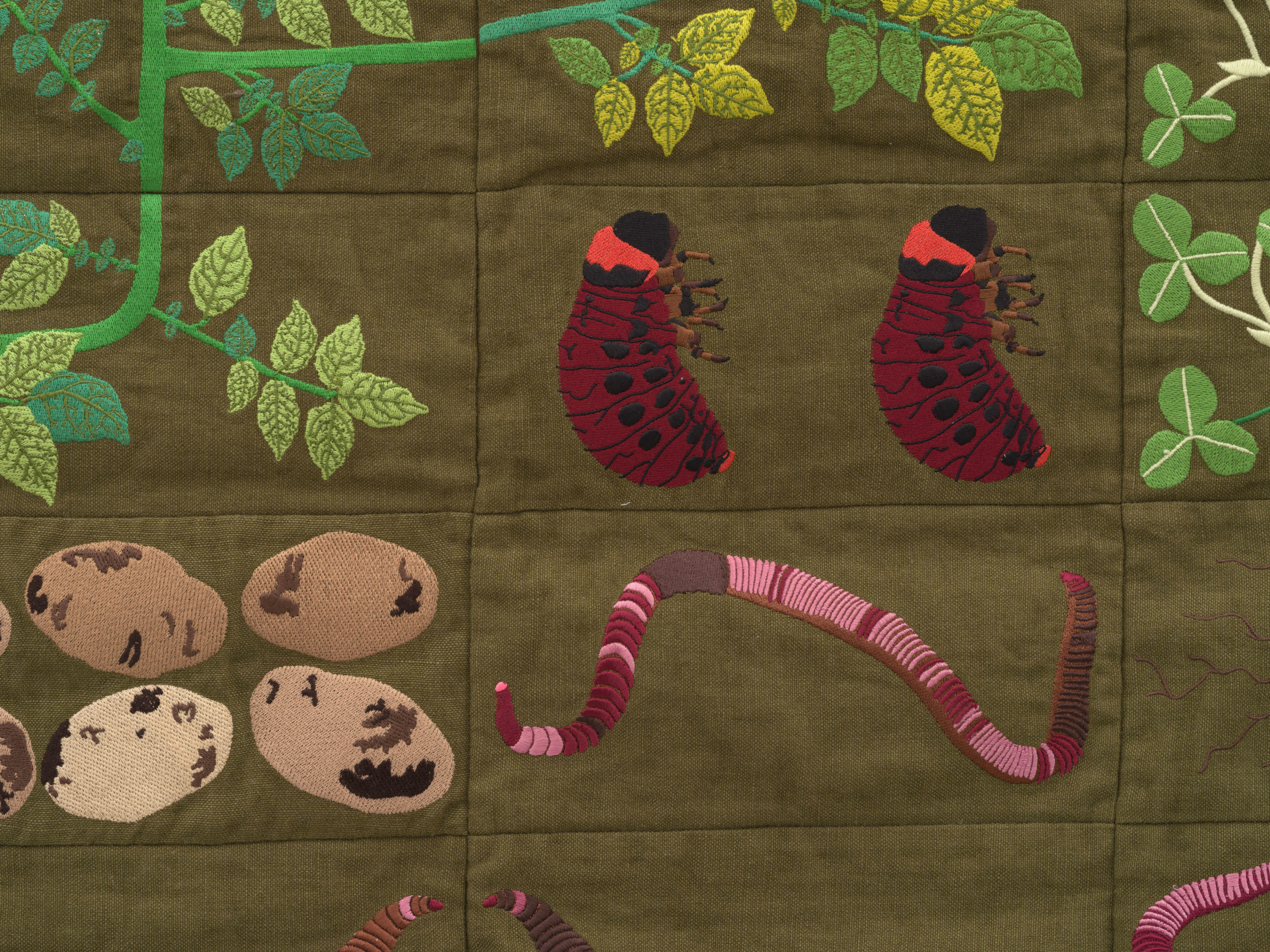 Embroidered quilt with earthworms, potato plants, clover plants, Colorado beetle larvae, Colorado be...