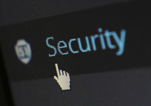 Curseur pointant sur le mot 'Security' à l'écran, illustrant un concept de cybersécurité ou de protection informatique.