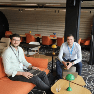 Deux collaborateurs Extia à Brest assis sur des fauteuils colorés dans un espace détente moderne, ordinateurs sur les genoux.