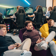 Salle Extia Gaming : des joueurs installés sur poufs jouent à la console, tandis qu’en fond, d'autres jouent à des jeux en ligne sur PC.