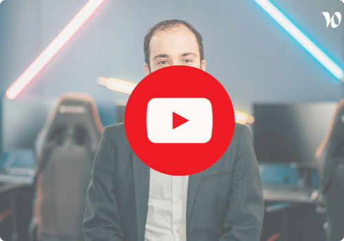 Jonathan, en costume sombre et chemise blanche, assis devant un bureau avec chaises gaming et néons colorés en arrière-plan. Un grand bouton rouge de lecture YouTube est centré sur l'image.