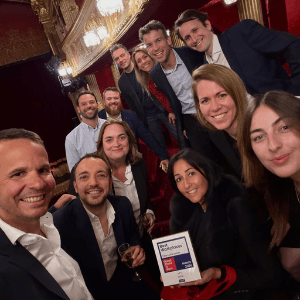 Les membres de la direction d'Extia et d'Extia Ingénierie posent ensemble lors de la cérémonie Great Place to Work 2026 dans un théâtre. Ils célèbrent leur victoire en tenant le trophée officiel au premier plan.