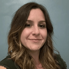 Portrait de Vanessa Georgescu Paquin, International HRBP. Elle a les cheveux châtains et ondulés. Elle est souriante et porte un haut vert foncé.