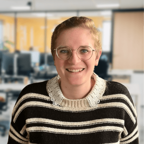 Portrait de Juliette Ferrari, Directrice recrutement et Projets IA. Elle est souriante, porte un pull a rayures noir et blanc et des lunettes rondes.