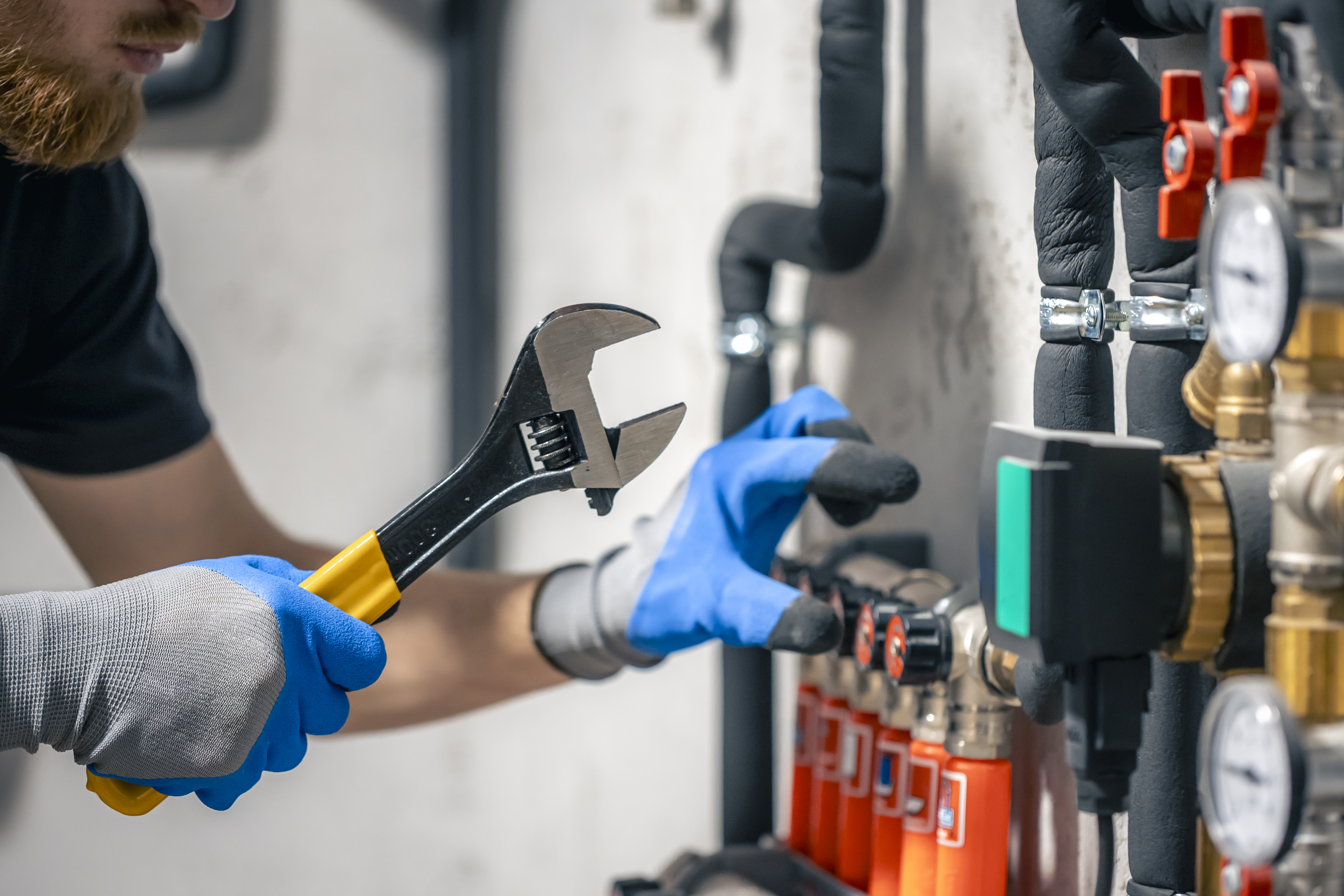 Professional plumber working on residential water supply system with modern equipment