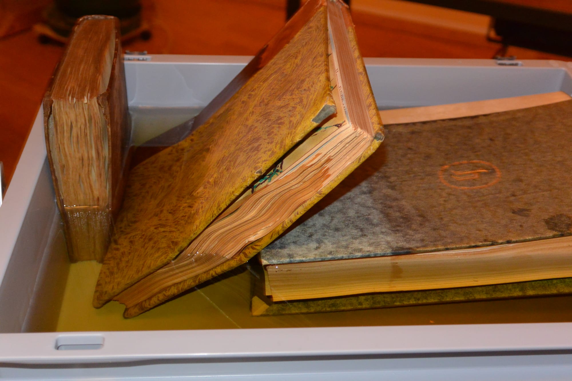 Books with half leather bindings in a bain-marie.