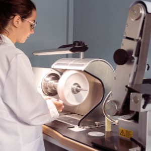 Watchmaker in smock polishing a watch