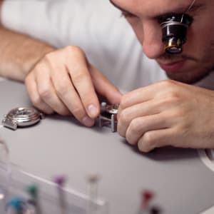 Watchmaker focused on assembling a mechanism