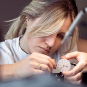 Watchmaker examining a watch dial