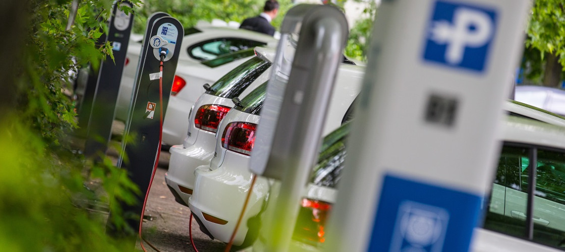 Electric cars stand next to charging stations Electric cars stand next to charging stations