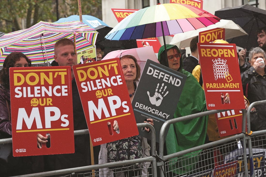 Protesters shelter from the rain outside the Supreme Court in London Protesters shelter from the rain outside the Supreme Court in London