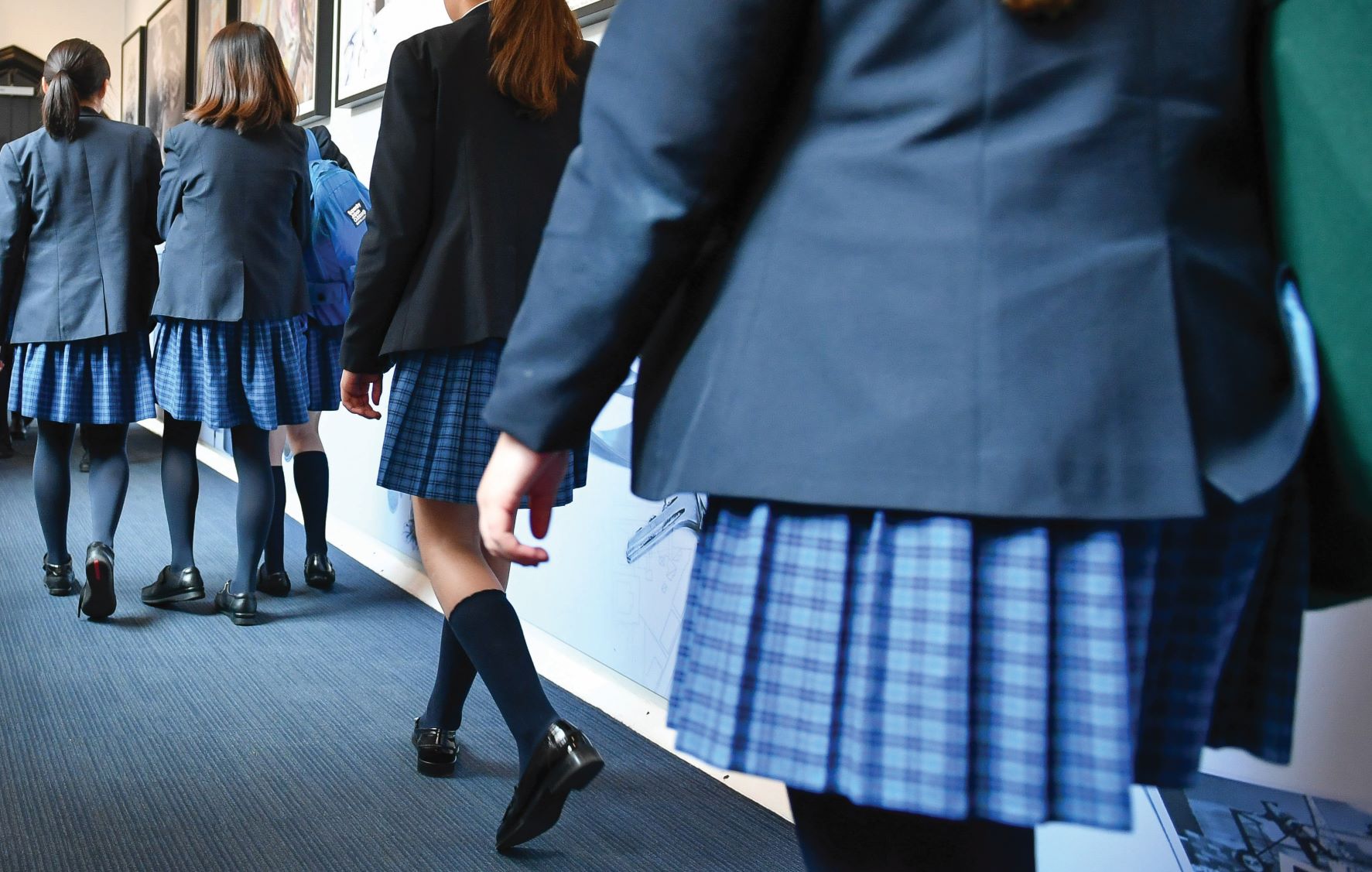 Students walking along a corridor in blue blazers and kilts Students walking along a corridor in blue blazers and kilts