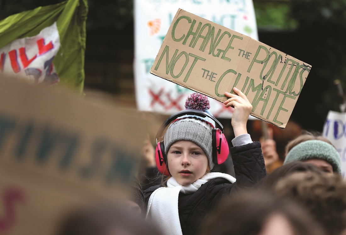 A climate protester holds up a sign reading 'Change the politics, not the climate' A climate protester holds up a sign reading 'Change the politics, not the climate'