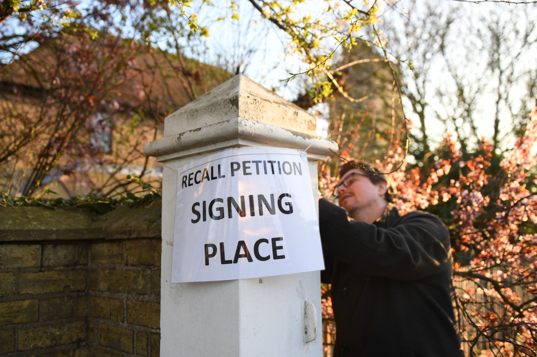 A 'recall petition signing place' sign is placed outside Bedford Hall in Thorney, Peterborough A 'recall petition signing place' sign is placed outside Bedford Hall in Thorney, Peterborough