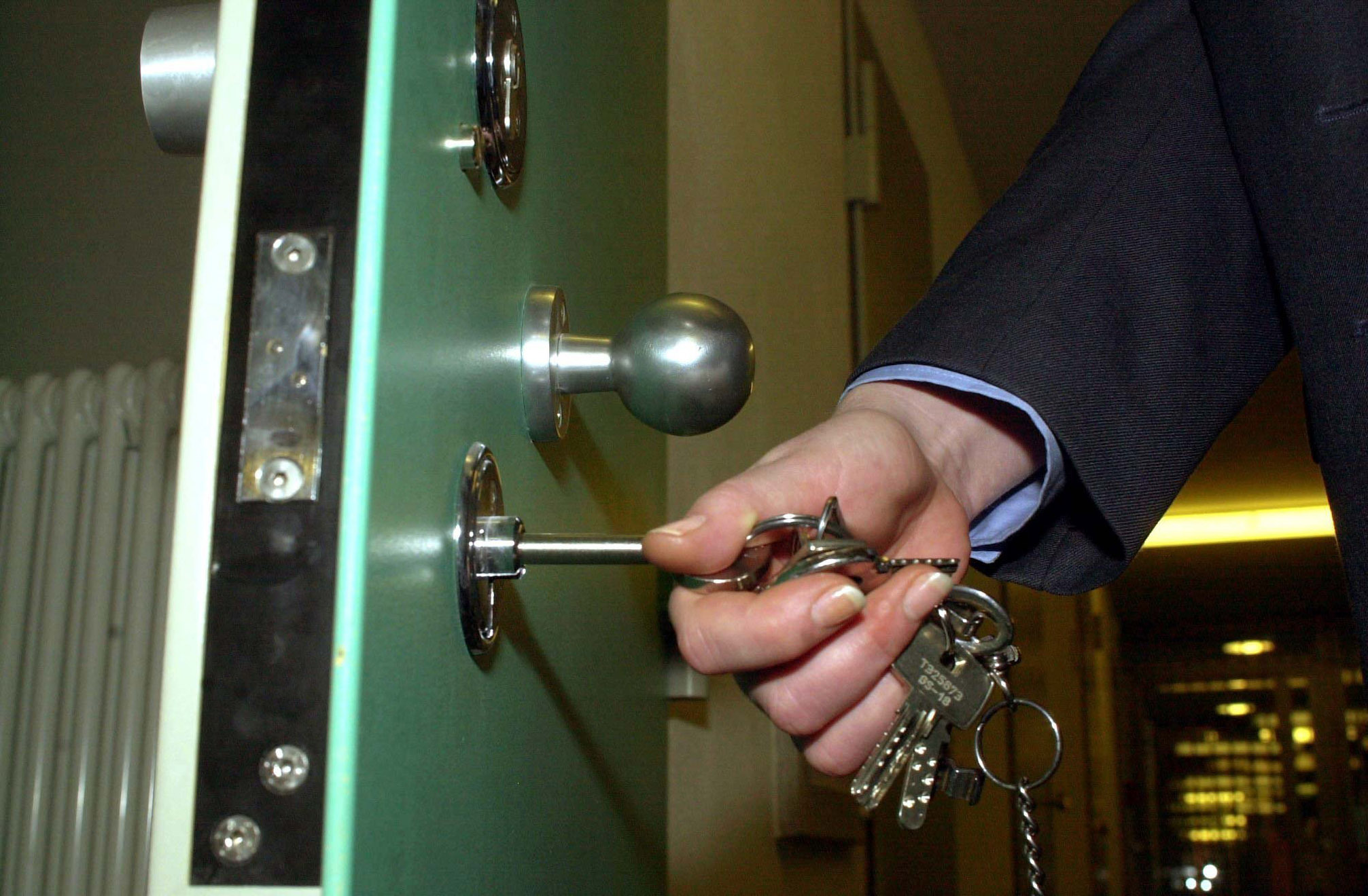 An officer closes a prison door An officer closes a prison door
