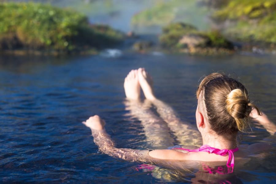 Tourist swimming in a hot spring near the Landmannalaugar camping area