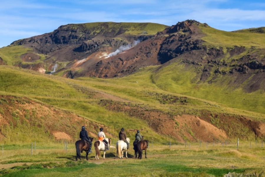 Tourists on a horseback riding tour through Icelandic landscape