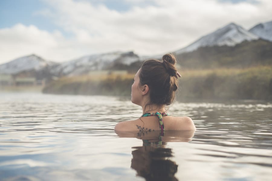 A female tourist having a nice swim in one of the best hot springs in Landmannalaugar