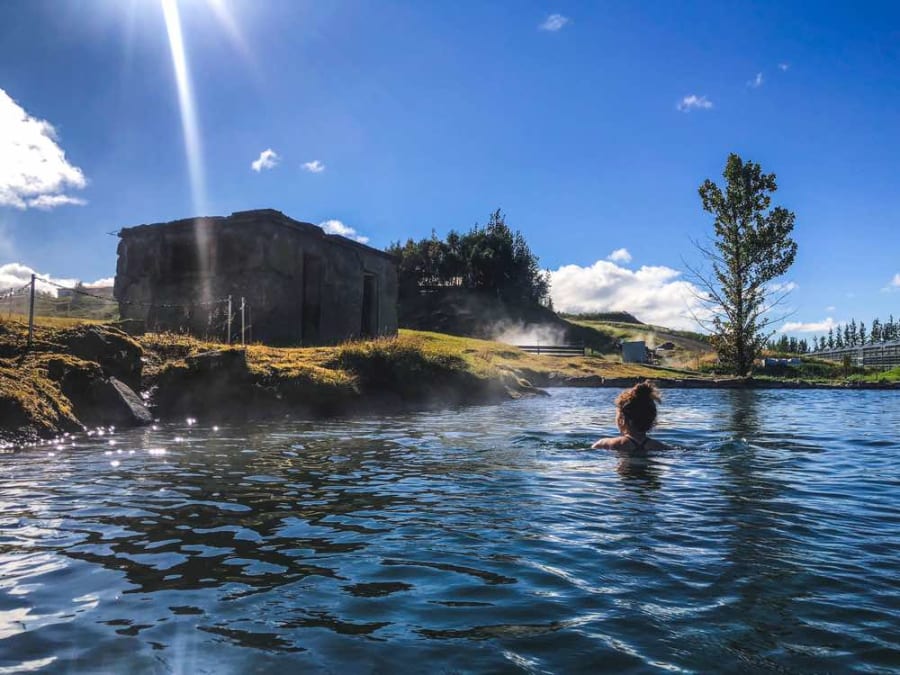 A woman having a dip in the Secret Lagoon, one of the best hot springs in Landmannalaugar