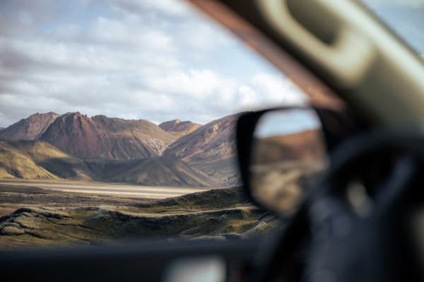 A panoramic view of vibrant rhyolite mountains under a dramatic Icelandic cloudy sky