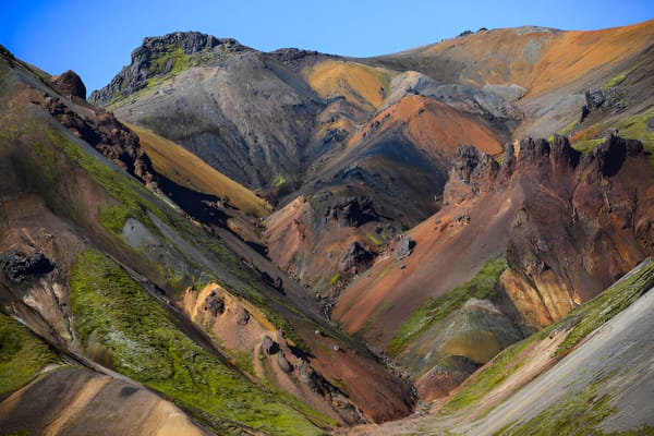 A rugged 4x4 super jeep traverses a vast, colorful volcanic landscape in Iceland’s highlands