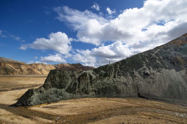 A rugged 4x4 highland bus traverses a vast, volcanic landscape toward Reykjavik