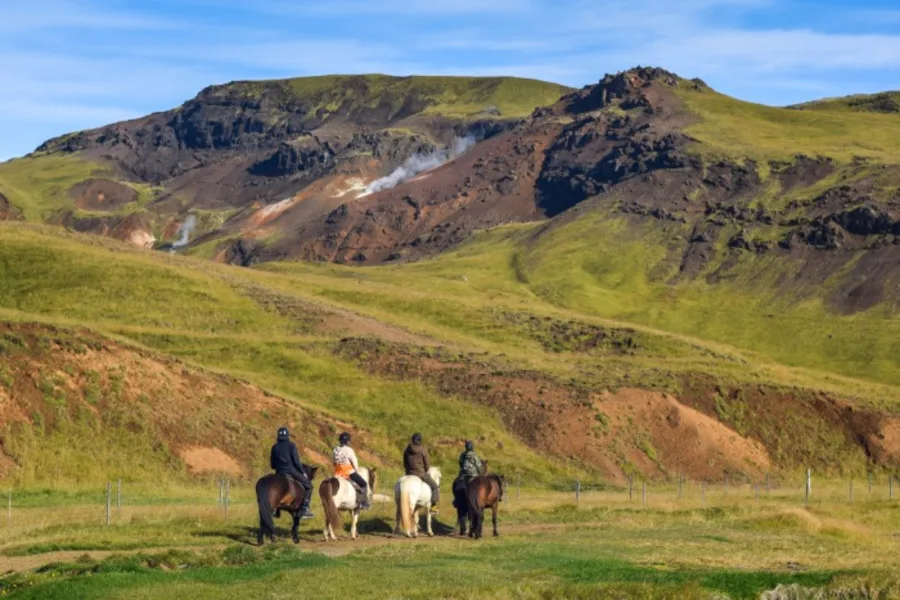 Tourists on a horseback riding tour through Icelandic landscape