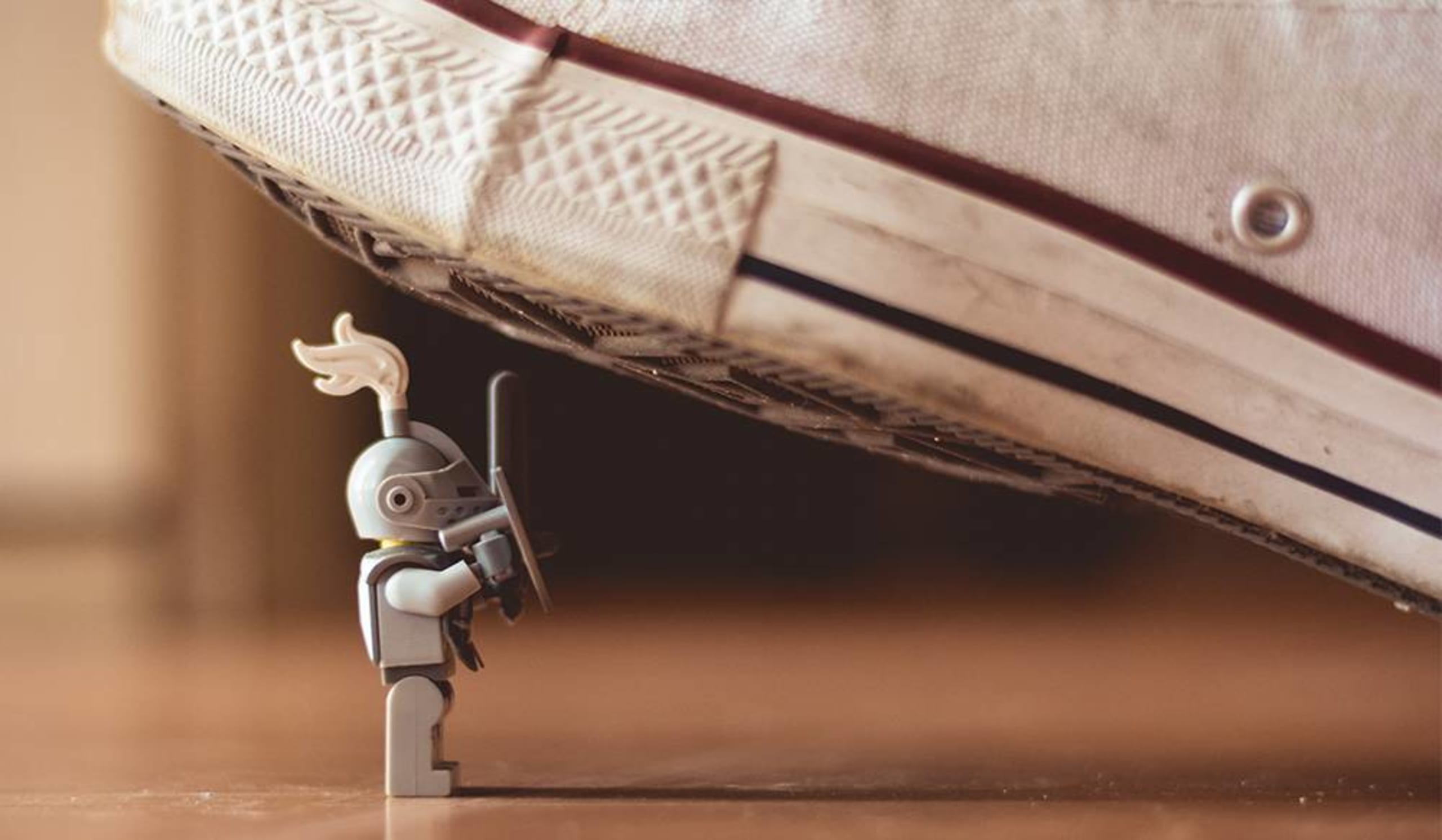 shoe about to step on a tiny toy knight