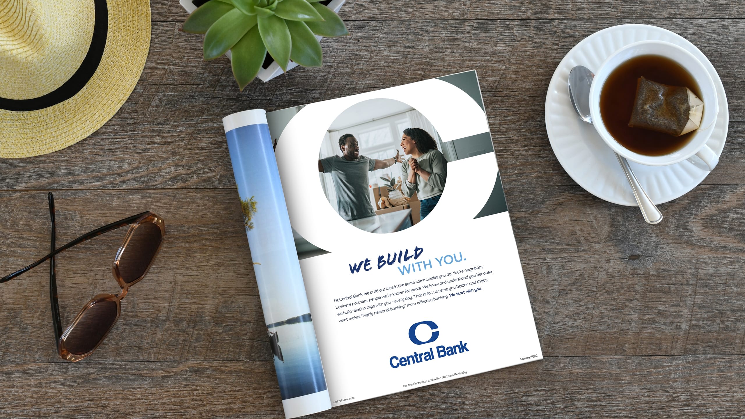 a central bank "we build with you" magazine ad on a dark wood table