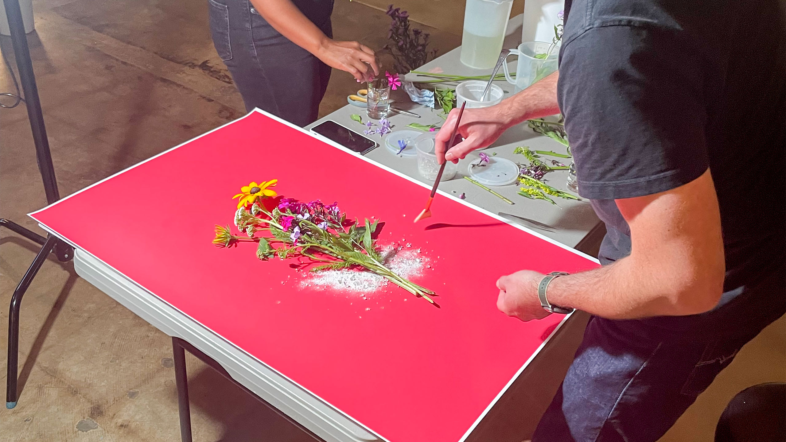 team setting up glass and flowers photoshoot