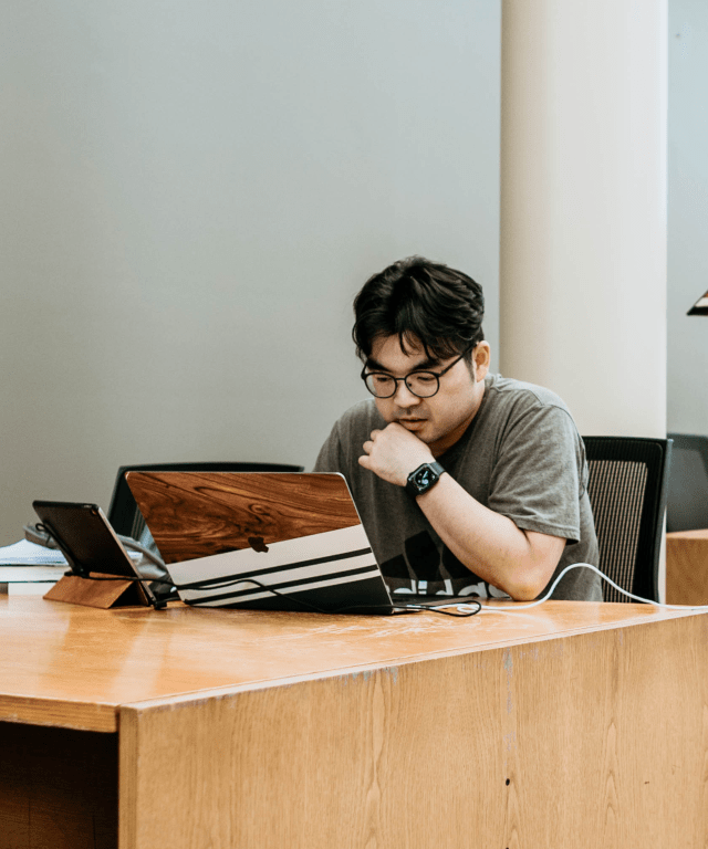 student typing on computer at the library