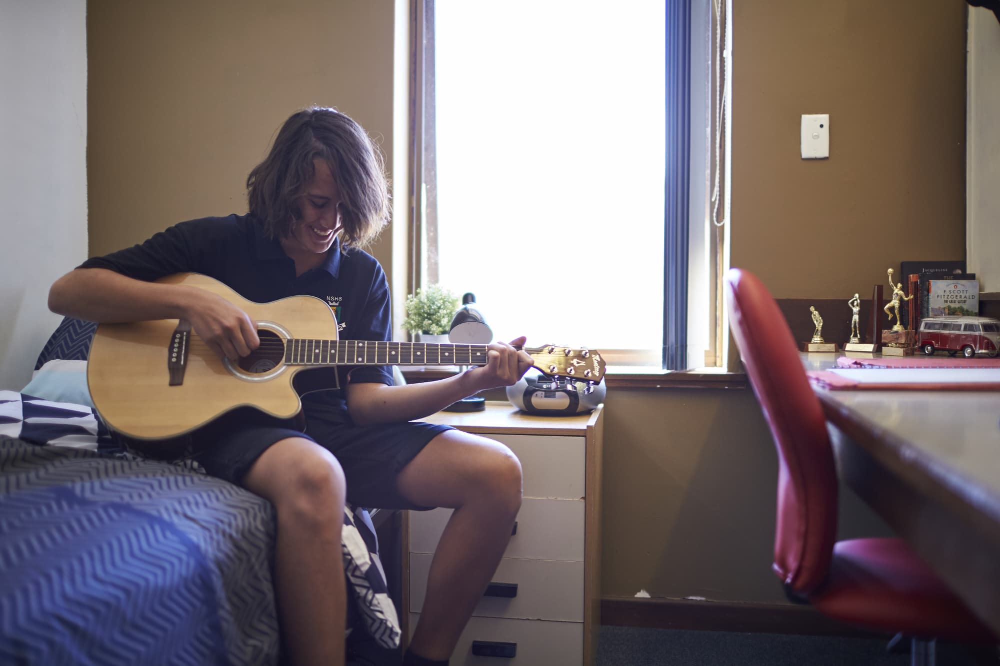 Boy playing guitar in his room