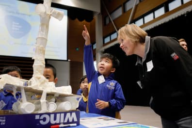 child pointing up with teacher looking on