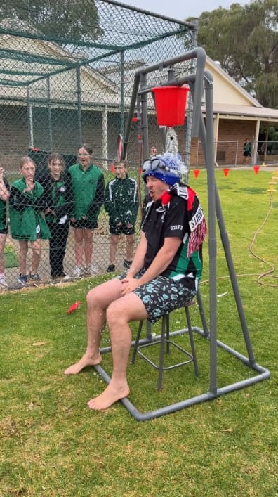 Deputy having a bucket of water poured over their head as part of the dunk the deputy challenge.