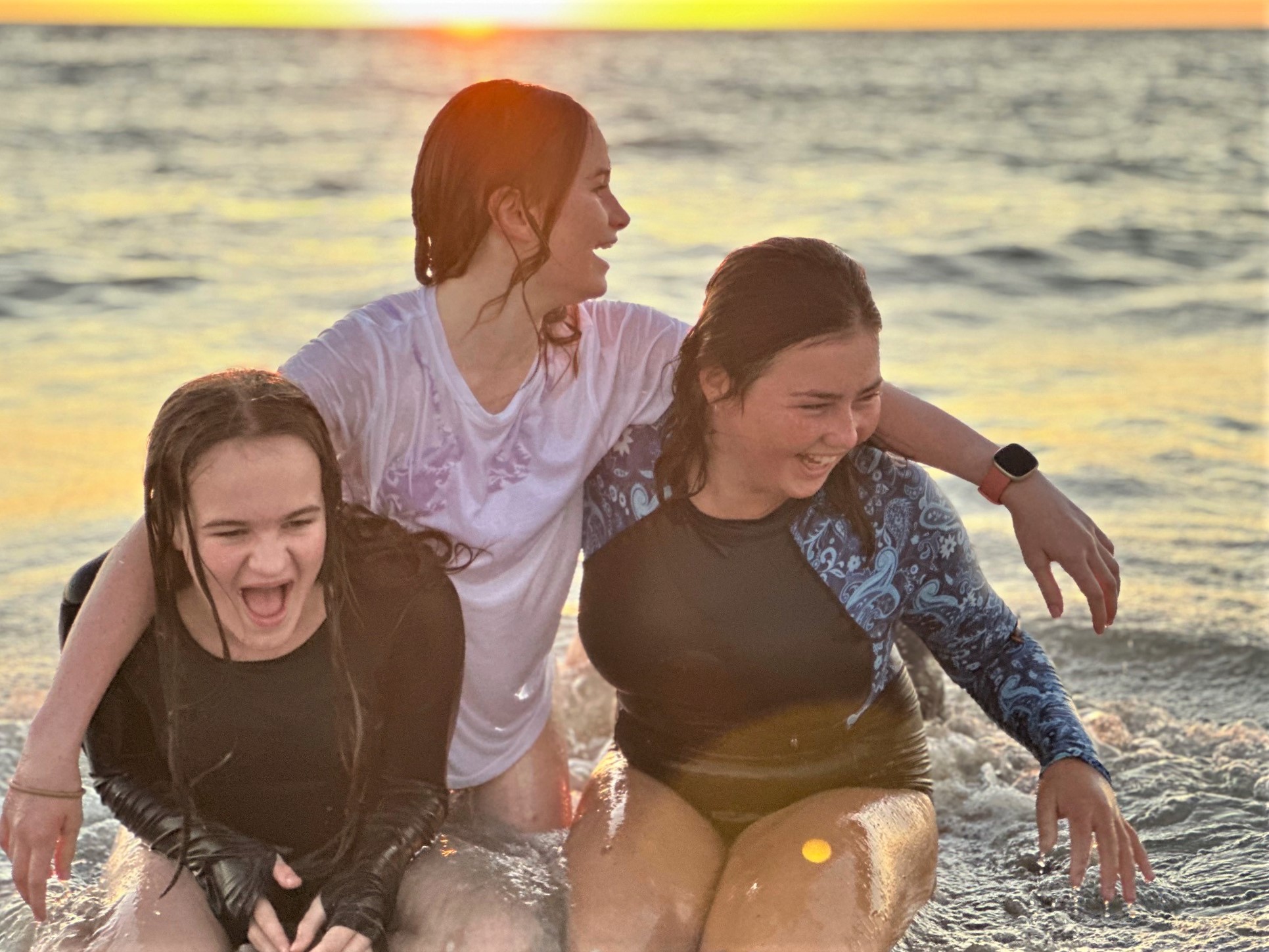 Girls splashing on the beach foreshore in the sunset