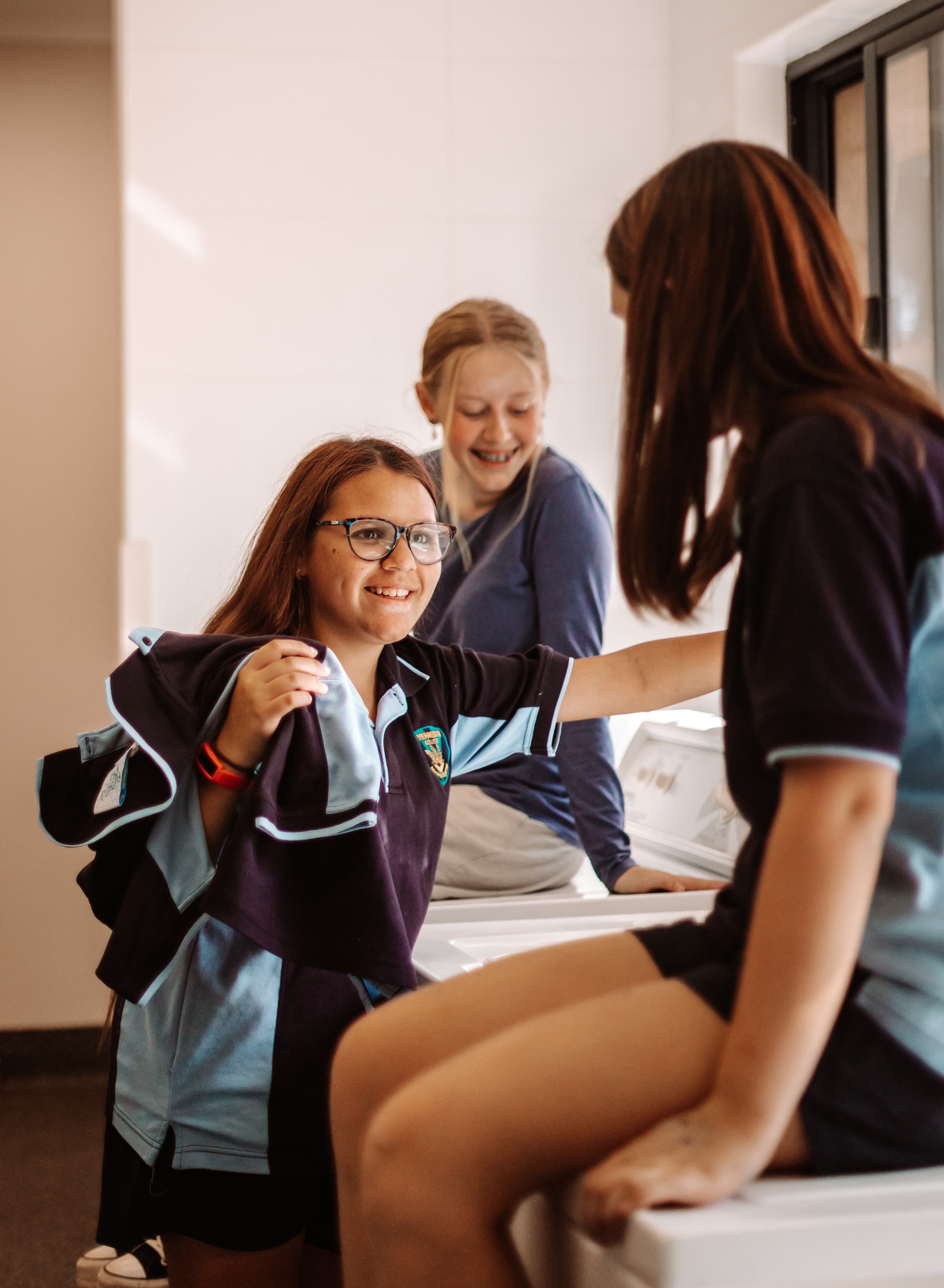 pic of Merredin residential college boarders smiling and folding laundry