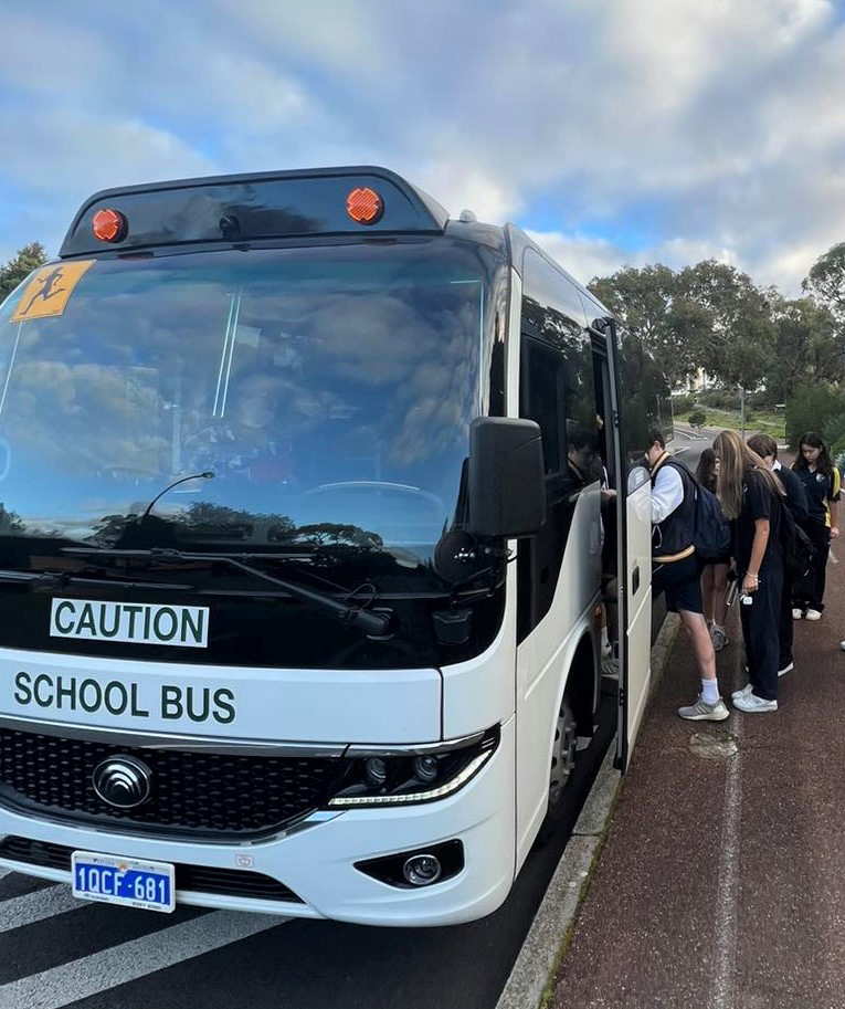 City Beach Residential College boarders lining up to get on college bus