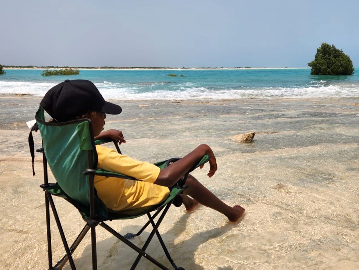 Boy lounging in a chair at the beach