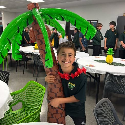 Albany Residential College boarders smiling holding an inflatable coconut tree