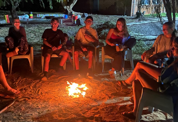 Geraldton Residential College boarders sitting around an evening campfire